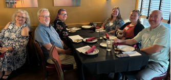 A group of people sitting at a table

Description automatically generated