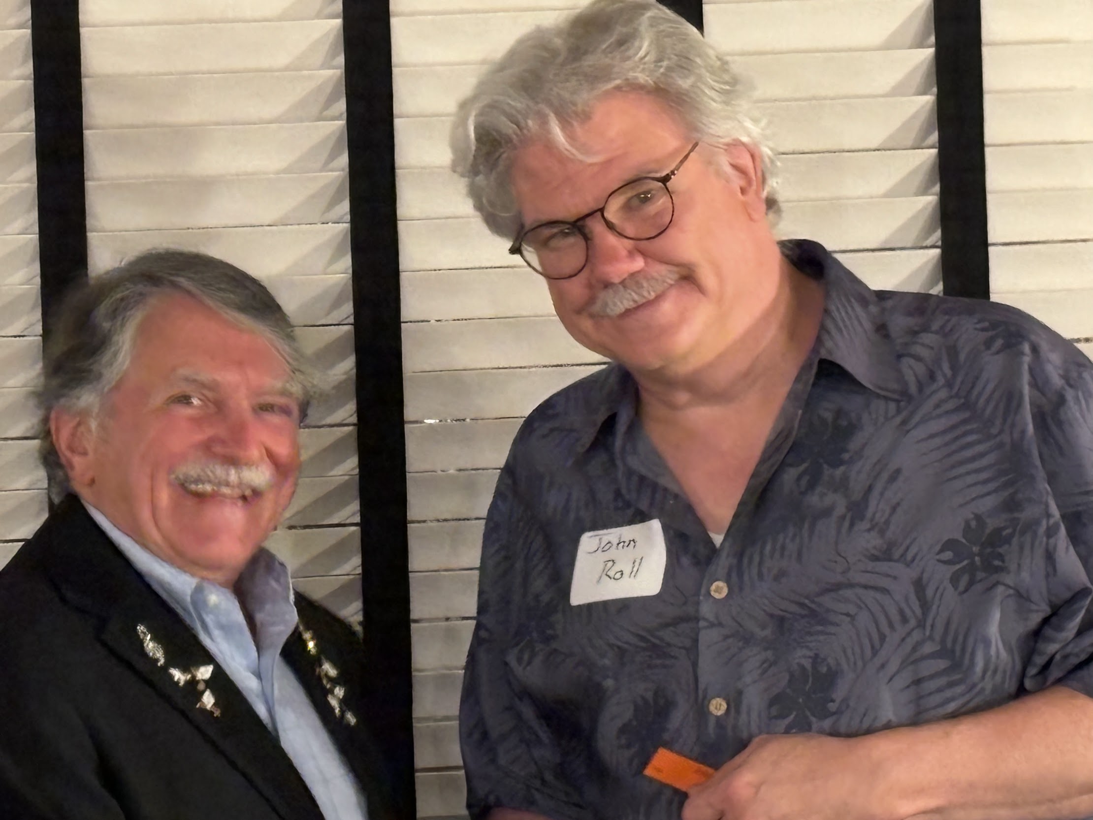 A couple of men smiling

Description automatically generated