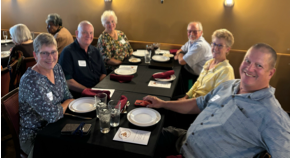 A group of people sitting at a table

Description automatically generated