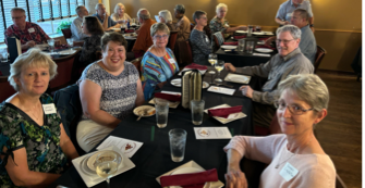 A group of people sitting at tables

Description automatically generated