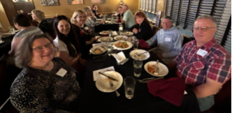 A group of people sitting at a table

Description automatically generated