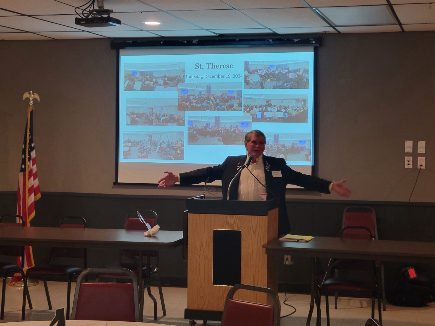 A person standing at a podium with his arms out
AI-generated content may be incorrect.