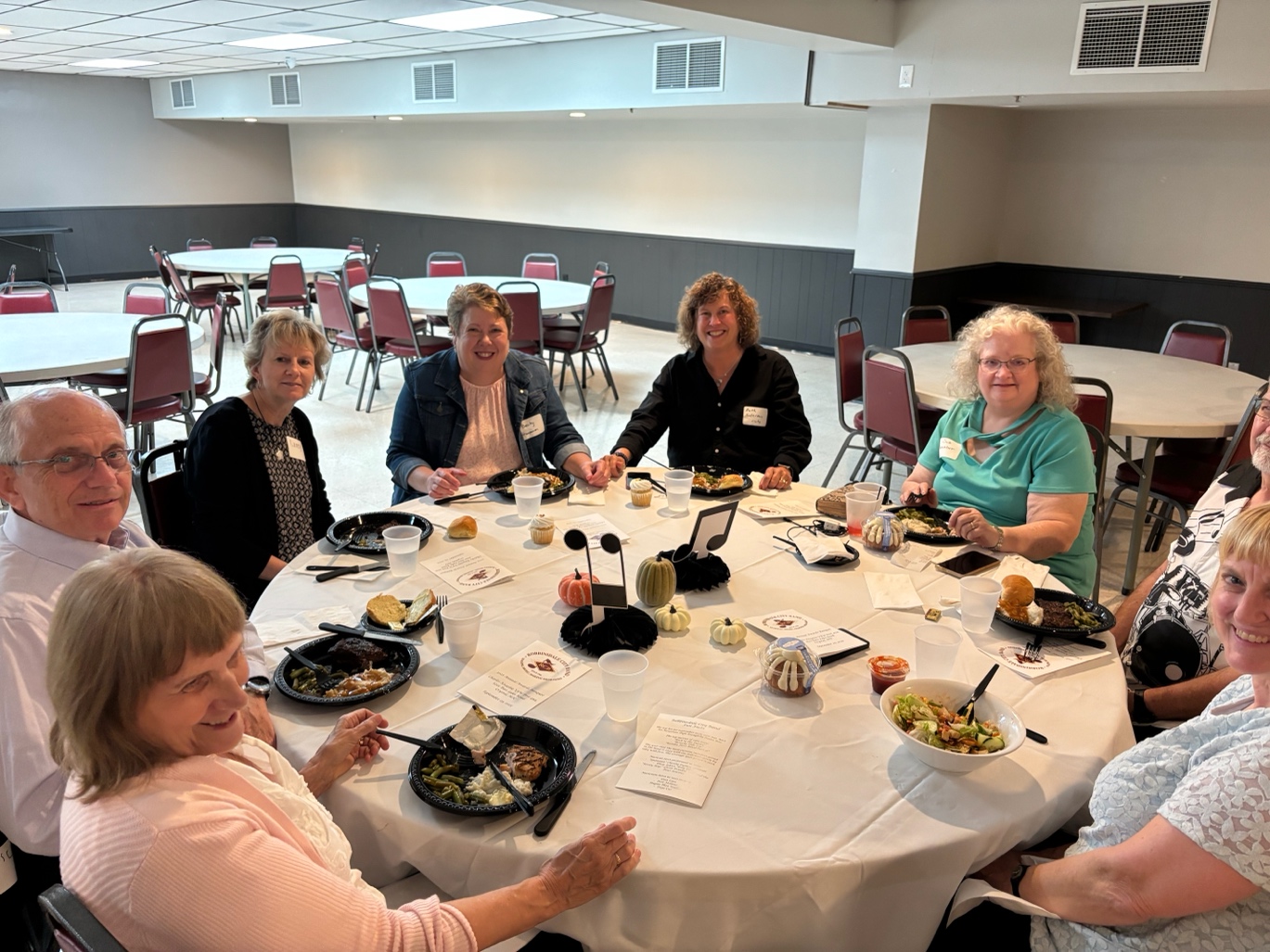 A group of people sitting around a table
AI-generated content may be incorrect.