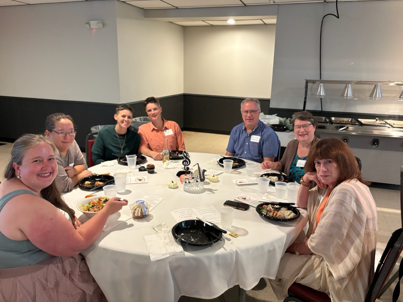 A group of people sitting around a table
AI-generated content may be incorrect.